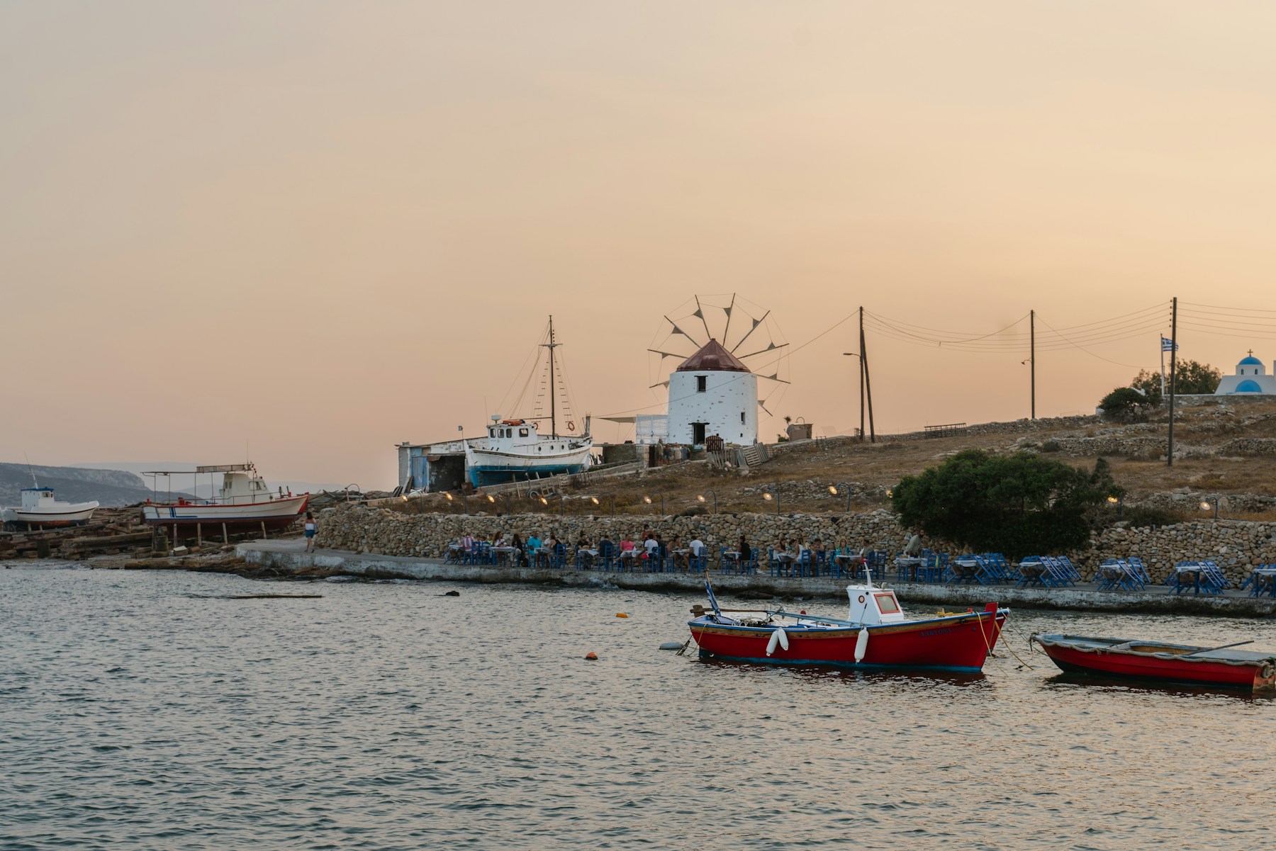 Παραδοσιακός ανεμόμυλος και ψαρόβαρκες στο ηλιοβασίλεμα των Κουφονησίων